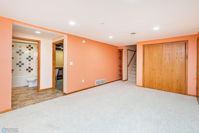 unfurnished bedroom with a closet and ensuite bathroom