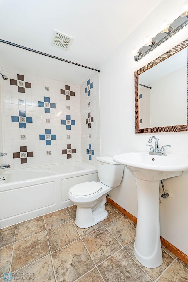 full bathroom with tiled shower / bath combo, toilet, and sink