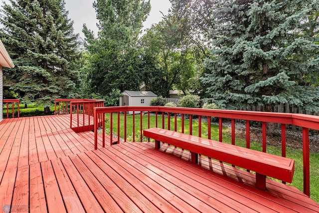 wooden deck with a storage shed and a yard