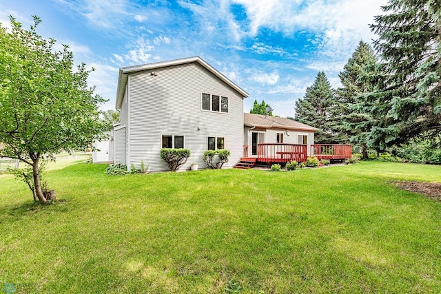 back of property with a lawn and a deck