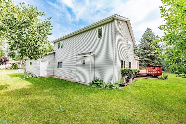 rear view of house featuring a yard and a deck