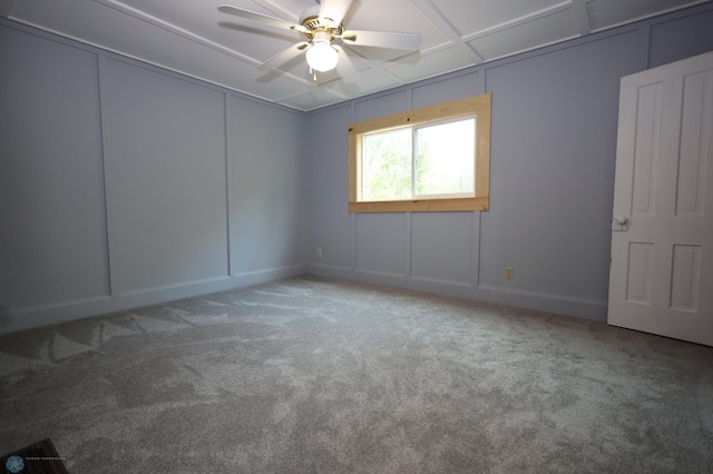 carpeted empty room with coffered ceiling and ceiling fan