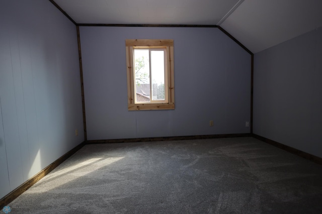 additional living space featuring carpet flooring and vaulted ceiling