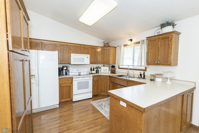 kitchen with white appliances, light hardwood / wood-style flooring, kitchen peninsula, sink, and lofted ceiling