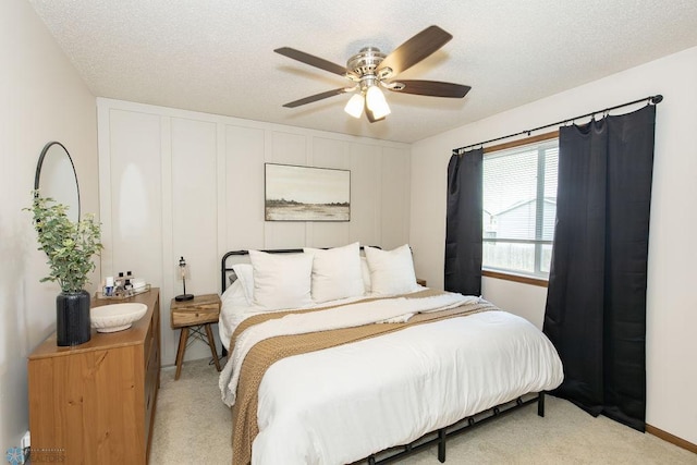 carpeted bedroom featuring a textured ceiling and ceiling fan