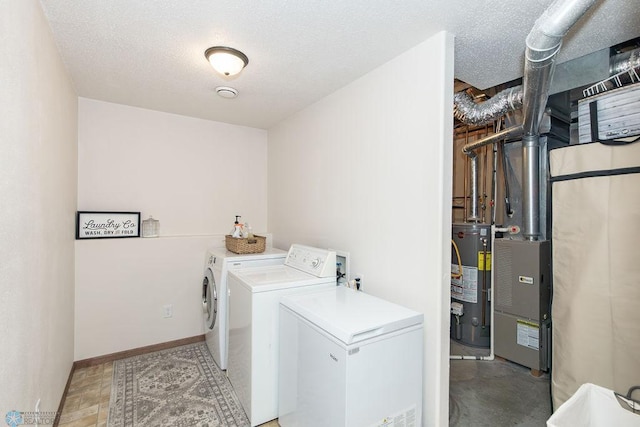 laundry area featuring gas water heater, washing machine and clothes dryer, and a textured ceiling