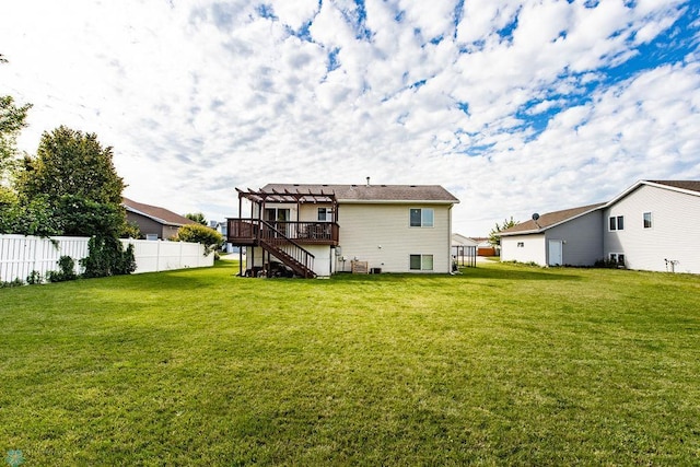 back of property featuring a wooden deck, a lawn, and a pergola