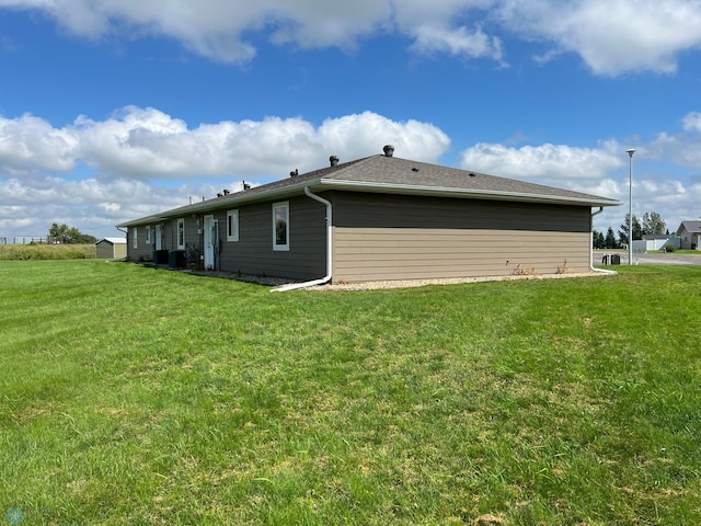 rear view of property with a lawn and cooling unit