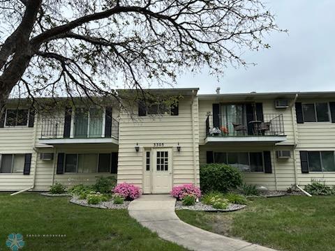 view of front of property with a balcony and a front yard