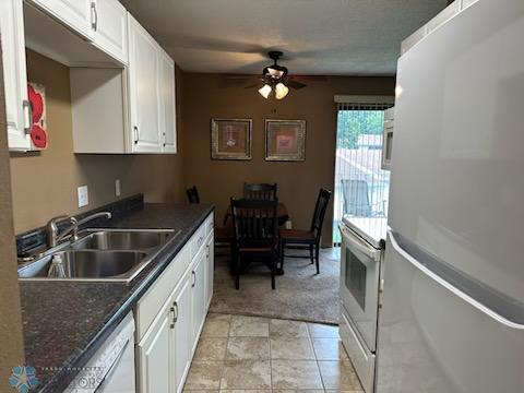 kitchen with sink, white appliances, white cabinetry, and light tile patterned flooring