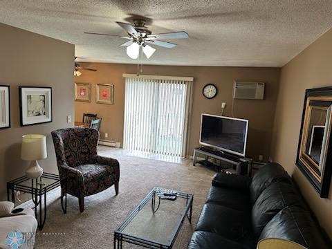 carpeted living room with a textured ceiling, a wall mounted AC, ceiling fan, and a baseboard heating unit