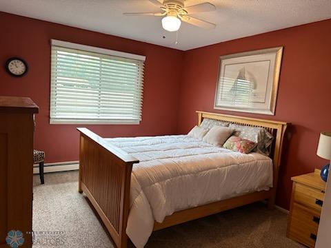 bedroom featuring carpet flooring, baseboard heating, and ceiling fan