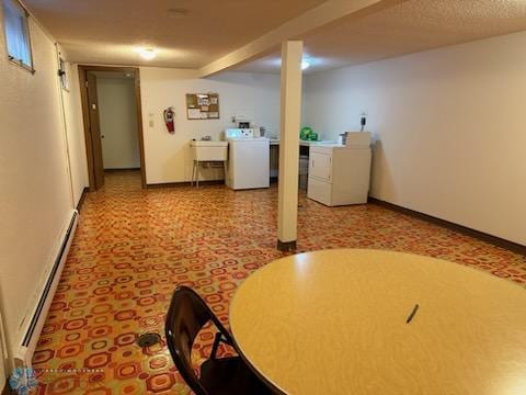 basement with a textured ceiling, sink, a baseboard radiator, and light colored carpet