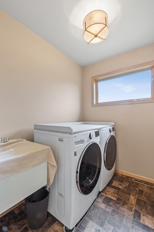 clothes washing area featuring sink and separate washer and dryer