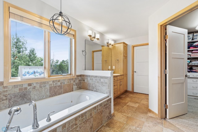 bathroom featuring vanity and tiled tub