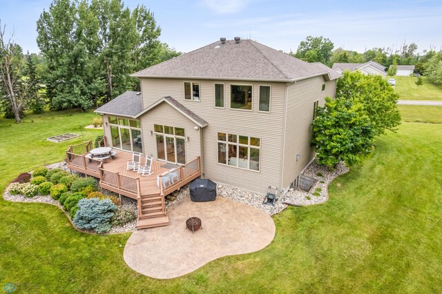 back of property featuring a wooden deck and a yard