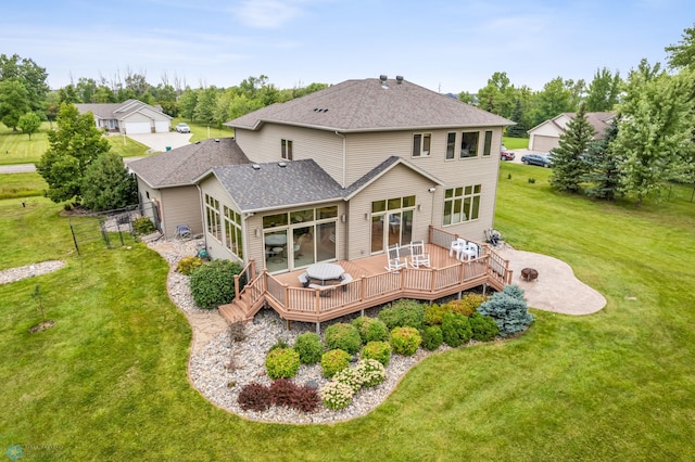 rear view of property featuring a sunroom, a deck, and a lawn