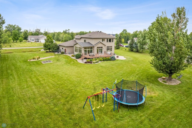 back of property with a lawn and a trampoline