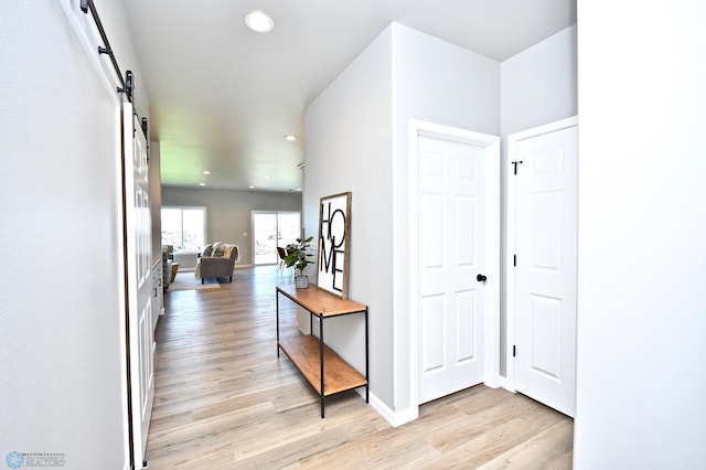 hall featuring light hardwood / wood-style flooring and a barn door