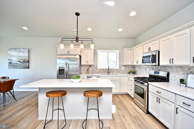 kitchen with a kitchen island, stainless steel appliances, and light hardwood / wood-style floors