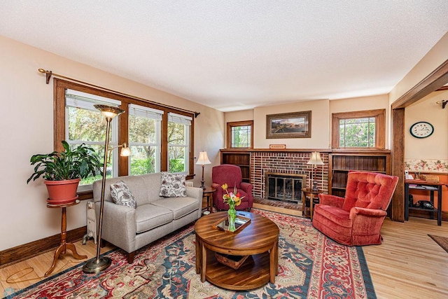 living room featuring a fireplace, a textured ceiling, and light hardwood / wood-style flooring