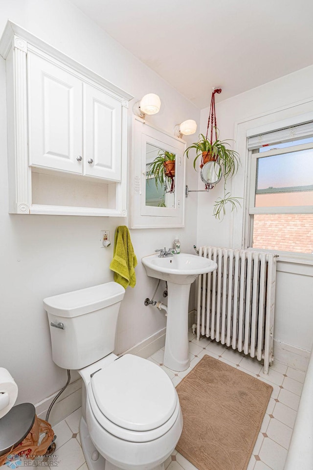 bathroom with tile patterned flooring, toilet, and radiator heating unit