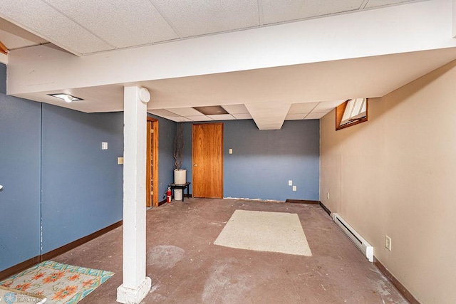 basement with a baseboard radiator and a paneled ceiling