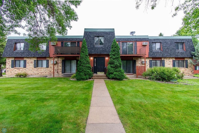 view of front of house with a balcony and a front yard