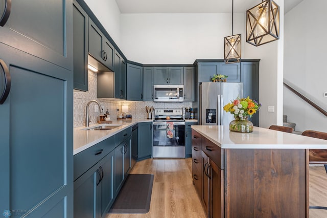 kitchen featuring a center island, light wood-type flooring, stainless steel appliances, sink, and a breakfast bar area