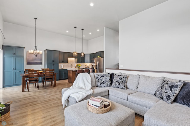 living room with light wood-type flooring and an inviting chandelier