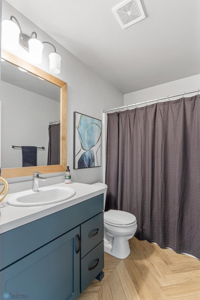 bathroom with vanity, toilet, and hardwood / wood-style flooring