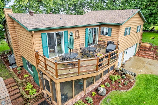 rear view of property featuring central air condition unit, a garage, a patio, and a yard