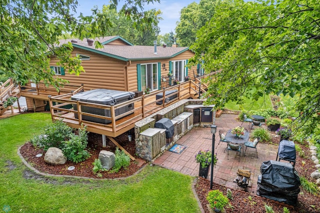 rear view of house with a wooden deck, a yard, and a patio area