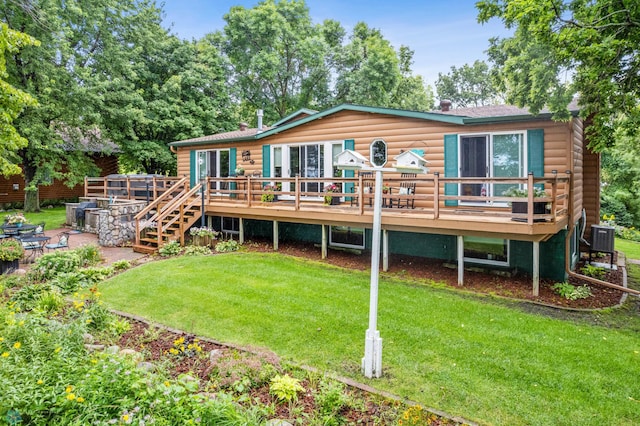 rear view of property featuring a lawn and a deck