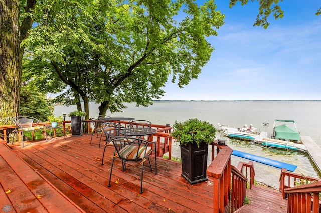 wooden terrace featuring a boat dock and a water view