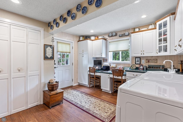 interior space featuring hardwood / wood-style flooring, sink, washer and clothes dryer, and a textured ceiling