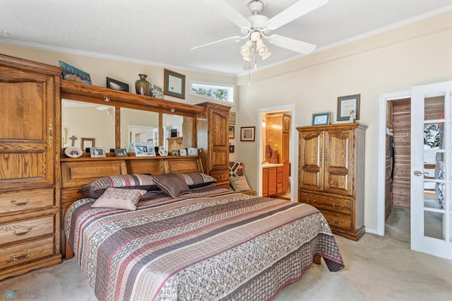 carpeted bedroom featuring ensuite bath, crown molding, ceiling fan, and a textured ceiling