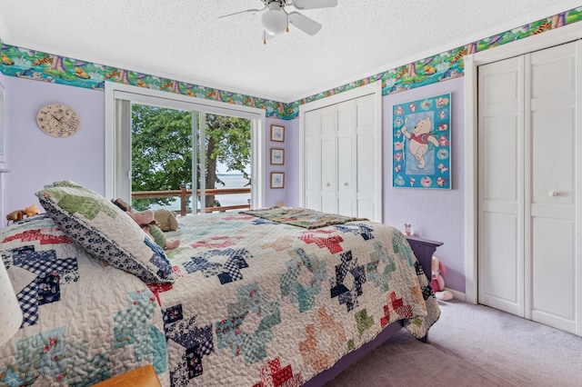 bedroom featuring a textured ceiling, carpet floors, access to exterior, two closets, and ceiling fan