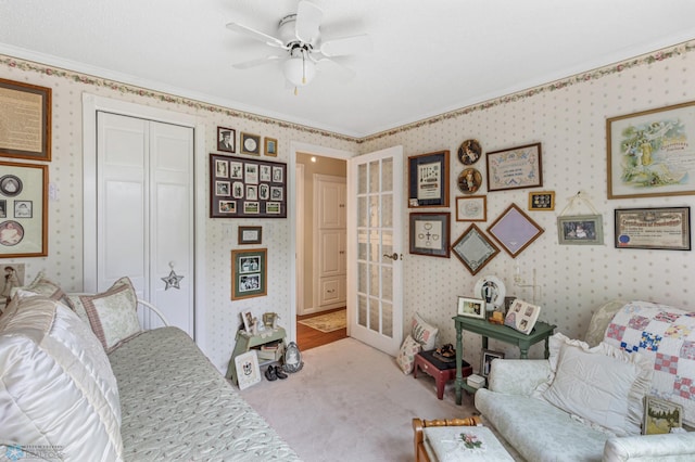 carpeted bedroom with crown molding, ceiling fan, and a closet