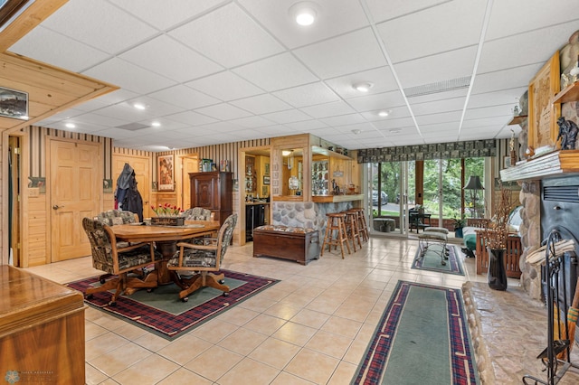 dining space with light tile patterned floors and a paneled ceiling