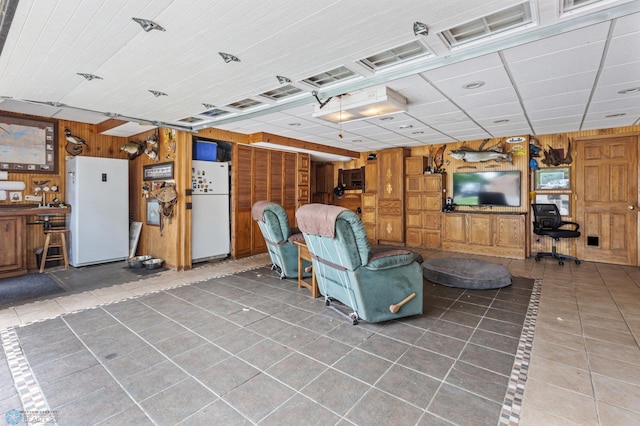 interior space with tile patterned flooring and wood walls