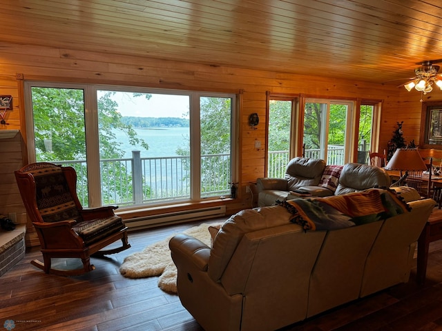 living room with a water view, a wealth of natural light, a baseboard radiator, and dark wood-type flooring