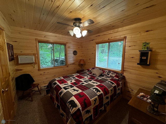 bedroom featuring ceiling fan, wooden walls, and multiple windows