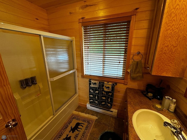 bathroom featuring tile patterned flooring, wood walls, vanity, and enclosed tub / shower combo