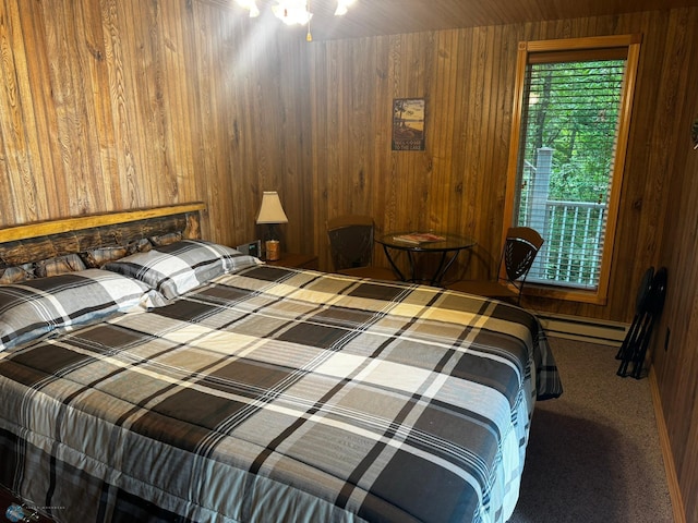 bedroom featuring wood walls, carpet flooring, and a baseboard heating unit