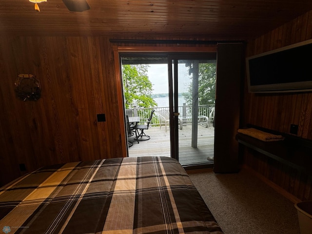 bedroom with wood walls, wood ceiling, and access to exterior