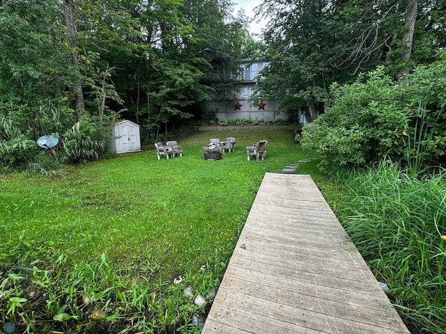 view of yard featuring an outdoor fire pit and a storage unit