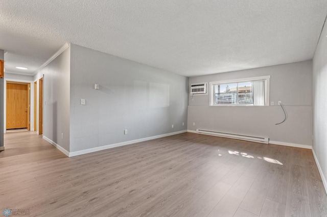 unfurnished room with a baseboard heating unit, a textured ceiling, a wall mounted AC, and light hardwood / wood-style floors