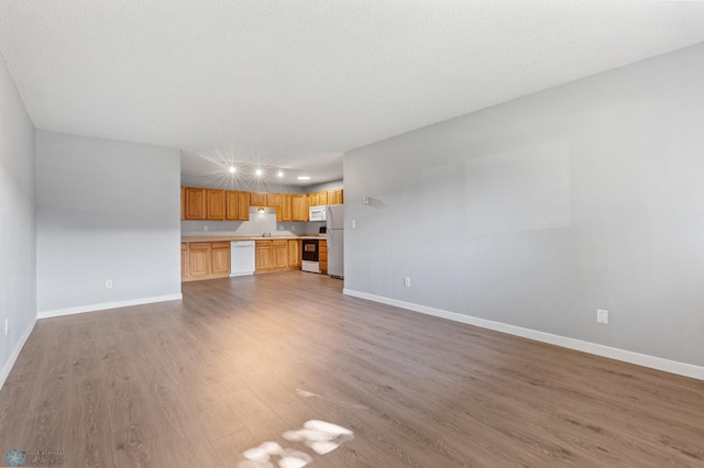 unfurnished living room featuring a textured ceiling and hardwood / wood-style floors