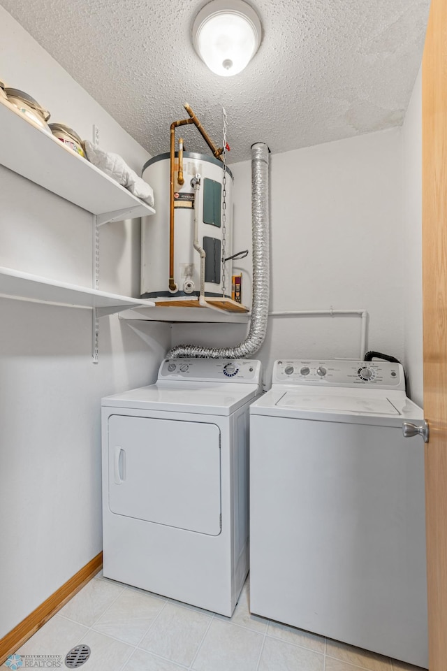 laundry room with a textured ceiling, washer and clothes dryer, light tile patterned floors, and water heater